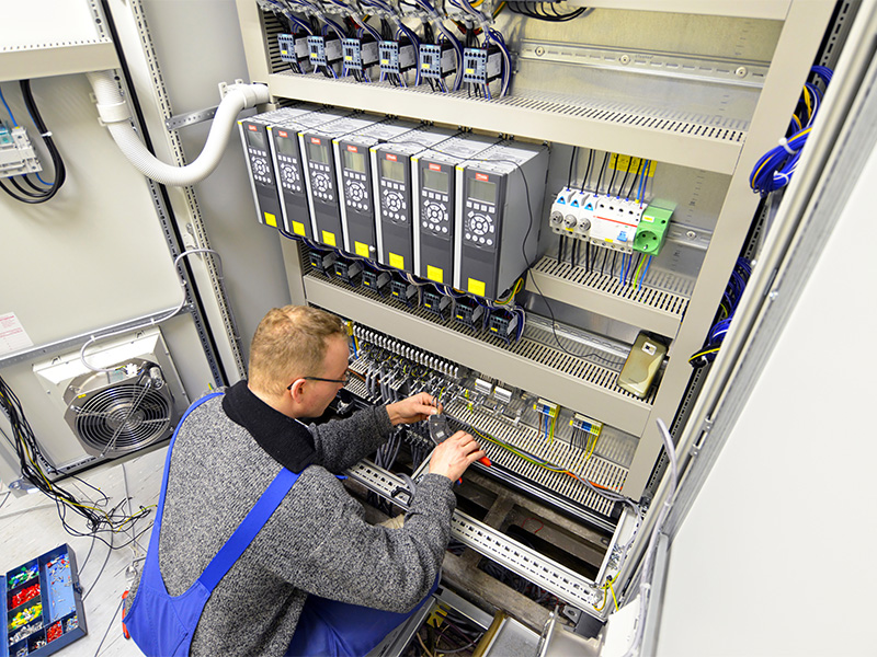 Elektromonteur arbeitet an modernen Schaltschränken zur sicheren Steuerung industrieller Anlagen und elektrischer Systeme in Herborn.